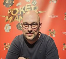 Ein professioneller Pokertisch mit grünem Filz, umgeben von Spielkarten, Jetons und einem Glücksbringer in Form eines vierblättrigen Kleeblatts.