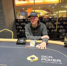 Ein luxuriöser Pokertisch mit grünem Filz, umgeben von eleganten Stühlen und verziert mit goldenen Details. Im Hintergrund sind Champagnergläser und Spielkarten zu sehen.