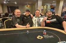 Ein Mann und eine Frau sitzen an einem Pokertisch und halten ihre Karten in der Hand. Sie schauen konzentriert auf den Tisch, um ihre nächsten Züge zu planen. Eine Mischmaschine und Jet