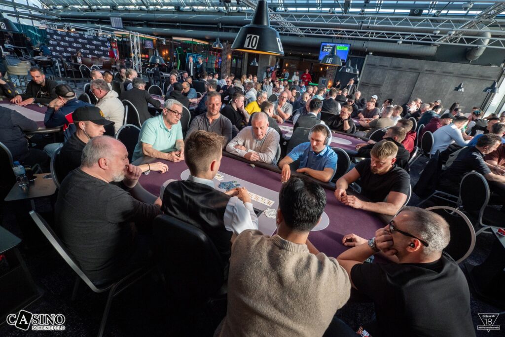 Ein buntes Bild von Spielkarten, die auf einem Tisch ausgelegt sind, um ein Pokerblatt zu bilden. Die Karten sind in verschiedenen Farben und Werten und liegen auf einem grünen Filztisch.