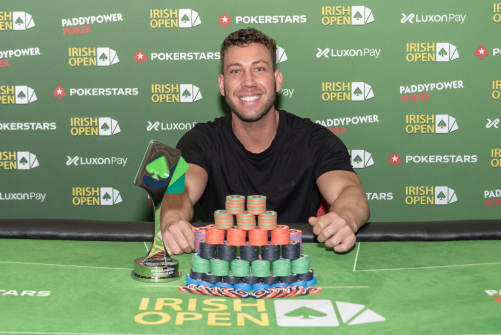 Ein Mann namens Alexandre Pruneau sitzt an einem Pokertisch während des JP Poker Masters-Turniers. Er hält Pokerchips in seiner Hand und konzentriert sich auf seine Karten.