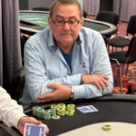 Ein professioneller Pokertisch mit grünem Filz, umgeben von Stühlen, Chips und Karten, bereit für eine spannende Pokerrunde.