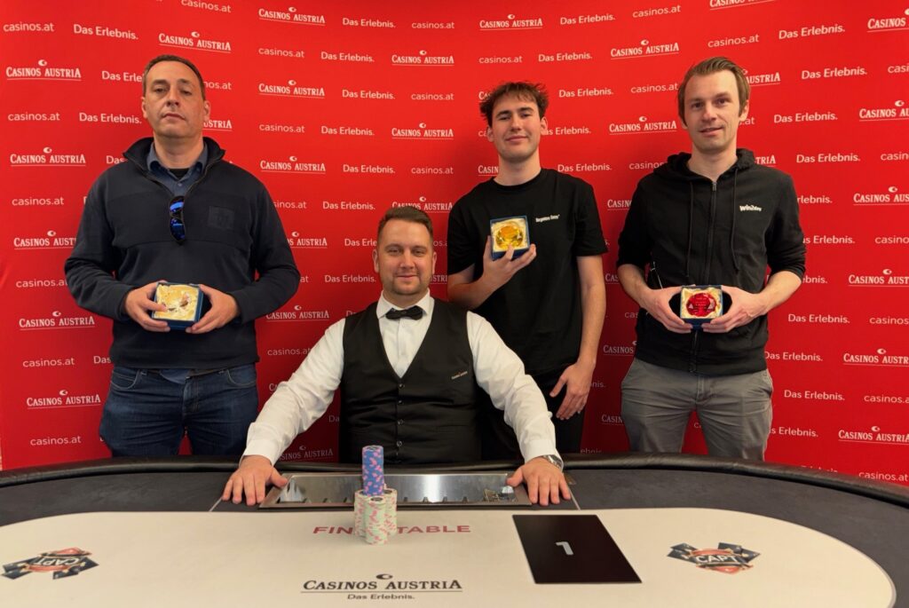 Ein Bild von einem Pokertisch mit Chips und Karten, umgeben von Spielern in einem Casino.