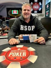 Ein Paar Freunde sitzen am Pokertisch und spielen Karten. Sie haben Chips vor sich und scheinen konzentriert zu sein.