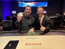 Ein Mann und eine Frau sitzen an einem Pokertisch und spielen gegeneinander. Der Mann hat eine Hand mit Karten in der Hand und sieht konzentriert aus, während die Frau ihre Karten betrachtet und läch