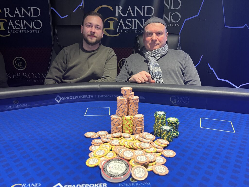 Ein leuchtendes Bild eines Poker-Turniers mit einem progressiven Bounty-Preis. Es zeigt Spieler an einem Tisch mit Stapeln von Chips und einer großen Anzeigetafel im Hintergrund.