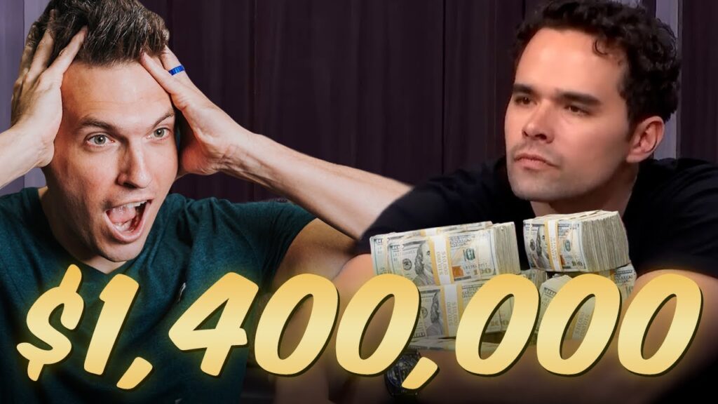 Ein Mann in einem dunklen Anzug und einer Brille sitzt an einem Pokertisch. Er hat lockiges Haar und schaut konzentriert auf seine Karten. Neben ihm sitzt ein anderer Mann.