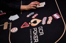 Ein stilvolles Casino-Interieur mit rotem Teppich, Deckenleuchtern und Pokertischen.