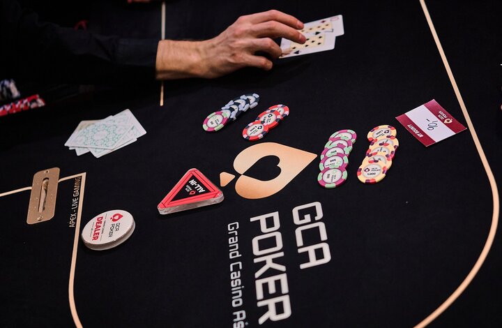 Ein stilvolles Casino-Interieur mit rotem Teppich, Deckenleuchtern und Pokertischen.