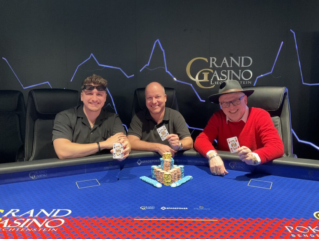 Ein Bild von einem Pokertisch mit grüner Filzoberfläche, umgeben von Spielkarten, Pokerchips und Getränken. Mehrere Spieler sitzen um den Tisch herum und konzentrieren sich