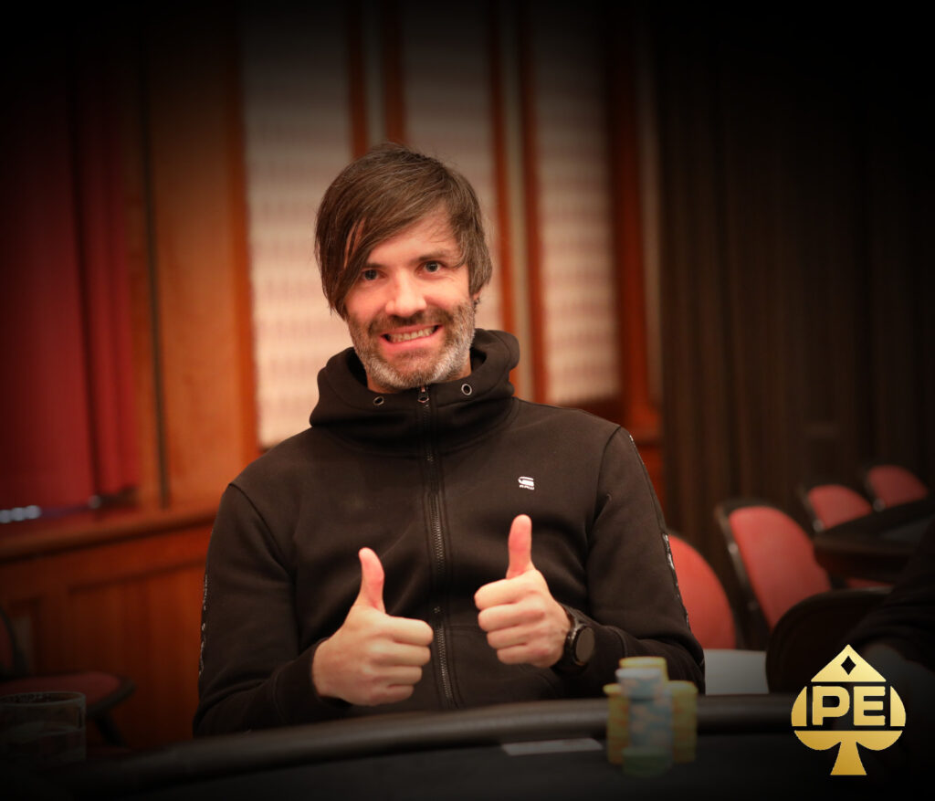 Ein junger Mann namens Stefan Lehner sitzt an einem Pokertisch und konzentriert sich auf sein Spiel. Er hat dunkles Haar und trägt ein schwarzes Hemd.