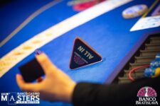 Ein Mann und eine Frau sitzen an einem Pokertisch und spielen Texas Hold'em. Der Mann hat einen Stapel Pokerchips vor sich und schaut konzentriert auf seine Karten, während die Frau entspannt lächelt