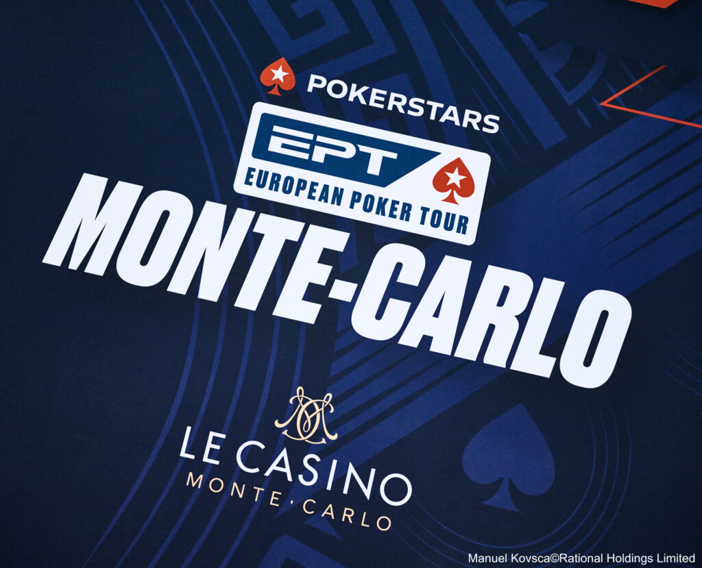 Ein Spieler mit Sonnenbrille und Kappe hält zwei Asse auf seinen Handkarten während er konzentriert auf den Poker-Tisch schaut, umgeben von Chips und anderen Spielern.