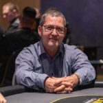Ein Mann und eine Frau spielen Poker in einem eleganten Casino mit grünen Filz-Tischen und professionellen Spielkarten. Der Mann hat einen Anzug an und die Frau trägt ein elegantes Abendkleid. Die Atmosph
