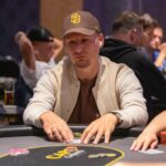 Ein farbenfroher Pokertisch mit Pokerchips, Spielkarten und Getränken, umgeben von Spielern in einer entspannten Atmosphäre.