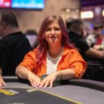 Ein eleganter Pokertisch mit grünem Filz, umgeben von Spielern, die Karten halten und Chips stapeln, während sie konzentriert sind. Die Spieler tragen Anzüge und sitzen in einem stil