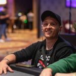 Ein professioneller Pokertisch mit grünem Filz, umgeben von Stühlen und Chips, bereit für ein spannendes Pokerspiel.