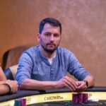 Ein professioneller Pokertisch in einem eleganten Raum mit grünen Filz und einem Stapel Pokerchips.