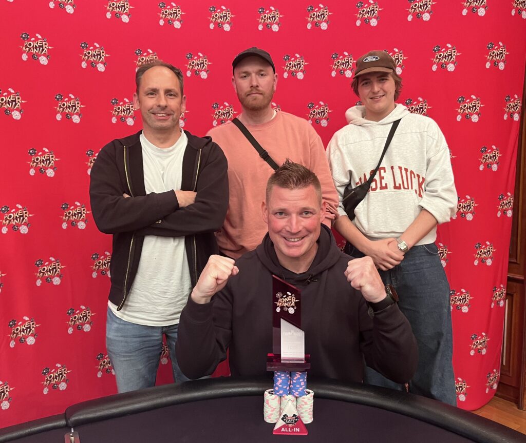 Ein Bild von vier Personen, die an einem Pokertisch sitzen und Karten spielen. Es herrscht eine konzentrierte Atmosphäre, während sie ihre Karten betrachten. Die Spieler sind verschiedener Herkunft und tr