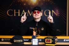 Ein Mann in einem dunklen Anzug und einer Sonnenbrille feiert seinen Sieg bei einem Pokerturnier, umgeben von jubelnden Zuschauern und Konfetti.