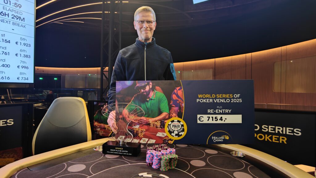 Ein Tisch mit grüner Filzdecke, an dem mehrere Spieler sitzen und Omaha Poker spielen. Die Spieler haben Karten in der Hand und Stapel von Pokerchips vor sich. In der Mitte des Tisches lie