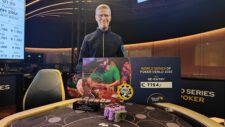 Ein Tisch mit grüner Filzdecke, an dem mehrere Spieler sitzen und Omaha Poker spielen. Die Spieler haben Karten in der Hand und Stapel von Pokerchips vor sich. In der Mitte des Tisches lie