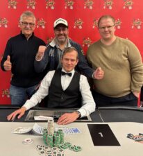 Ein Mann, der Poker spielt, sitzt an einem Tisch mit Chips und Karten.