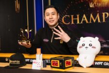 Ein Mann feiert seinen Sieg beim 25K PLO-Turnier von Triton in Monte Negro. Er hält strahlend seine Trophäe in die Luft, umgeben von jubelnden Menschen und einer beeindr