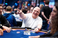 Ein Mann namens Andreas Göller sitzt an einem Pokertisch, hält Karten in der Hand und schaut konzentriert auf seine Gegner.