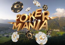 Ein Gruppenfoto von Pokerspielern in einem Casino. Sie sitzen an einem Tisch mit grünen Filz und halten Karten in der Hand. Im Hintergrund sind weitere Spieler und Zuschauer zu sehen.
