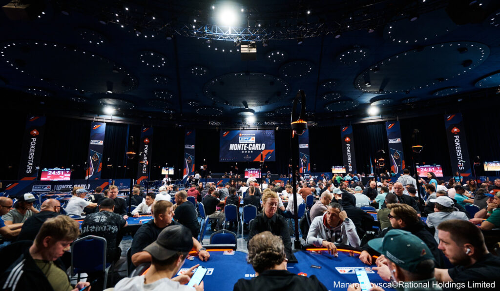 Ein Mann sitzt an einem Pokertisch und betrachtet konzentriert seine Karten. Im Hintergrund sind andere Spieler und Dealer zu sehen. Die Atmosphäre ist angespannt und professionell.