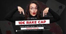Ein Stapel von Casino-Chips und Bargeld, umgeben von Pokerkarten und einem Rake Cap auf einem grünen Pokertisch.