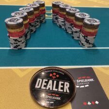Ein Mann spielt Poker mit einem Dummy als Gegner in einem gemütlichen Raum mit Holzmöbeln und einer Lampe.