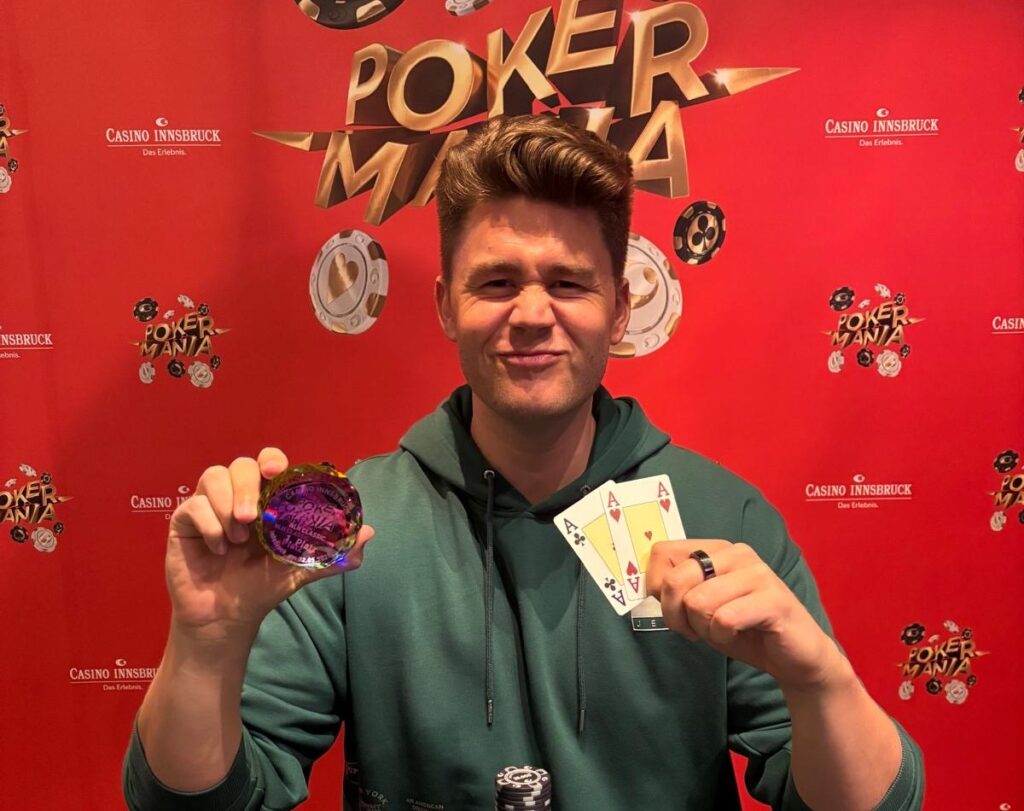 Ein Mann sitzt an einem Pokertisch, umgeben von Chips und Karten. Er schaut konzentriert auf seine Hand.