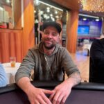 Ein Mann und eine Frau sitzen an einem Pokertisch und spielen Texas Hold'em. Der Mann hat eine Pokerhand mit drei Königen und die Frau hat eine Pokerhand mit zwei Assen. Beide schauen konzentriert auf