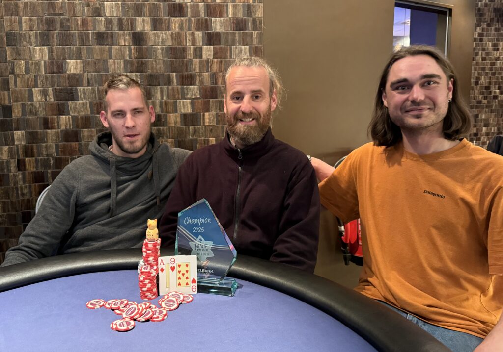 Ein professioneller Pokerspieler mit einem Pokal in der Hand, der den Sieg bei einem Frühjahrs-MVP-Turnier feiert.