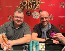 Ein Tisch mit grüner Pokerauflage, umgeben von Spielern, die Pokerchips stapeln und Karten halten. Ein Dealer in der Mitte des Tisches mischt die Karten. Es herrscht eine