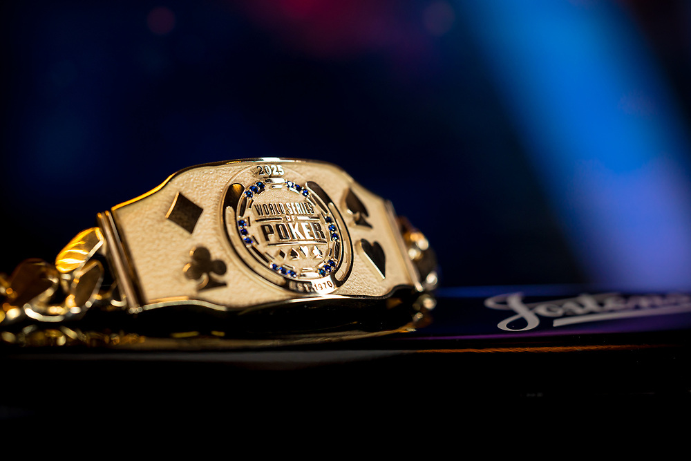 Ein Spieler nimmt an einem Pokerturnier der World Series of Poker (WSOP) teil und betrachtet konzentriert seine Karten. Die Atmosphäre ist intensiv, mit vielen anderen Spielern im Hintergrund.