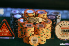 Ein Mann mit dunklen Haaren und einer Sonnenbrille trägt stolz ein goldenes Armband mit der Aufschrift "WSOP 2025 Bracelet". Er lächelt in die Kamera und steht vor einem