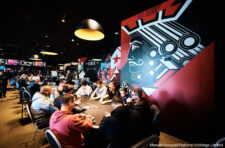Ein stilllebendes Arrangement von Pokerspielkarten, die in einem Fächer angeordnet sind und auf einem Holztisch liegen.