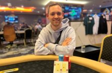 Ein Tisch mit Pokerkarten, Pokerchips und Spielern, die an einem Pokerspiel teilnehmen.