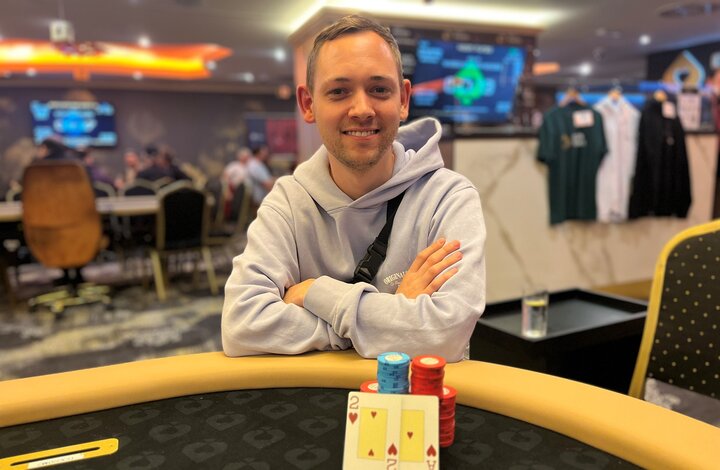 Ein Tisch mit Pokerkarten, Pokerchips und Spielern, die an einem Pokerspiel teilnehmen.