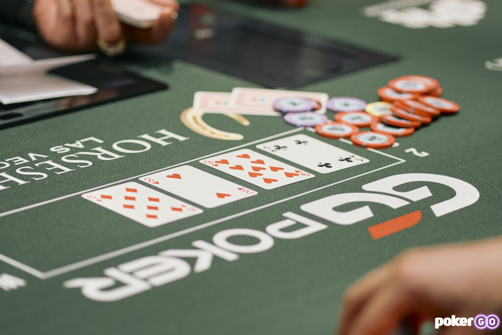 Ein Stapel von Pokerchips und Spielkarten auf einem grünen Pokertisch während des World Series of Poker-Events, fotografiert von MiguelC.