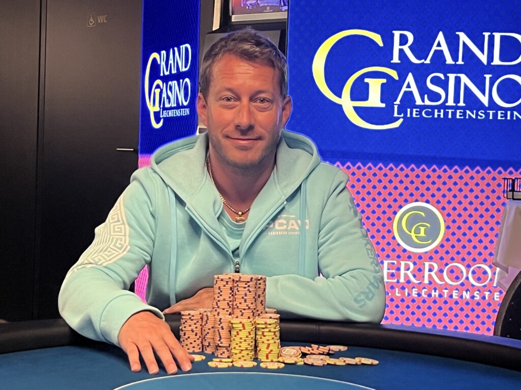 Ein Mann und eine Frau spielen Poker an einem eleganten Tisch in einem luxuriösen Casino. Die Frau hat gerade zwei Karten ausgeteilt und schaut konzentriert auf ihre Hand, während der Mann seine Karten betr