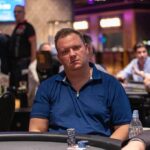 Ein professioneller Pokertisch mit grünem Filz, umgeben von Stühlen und Chips, bereit für ein spannendes Pokerspiel in einem eleganten Raum.