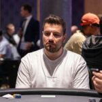Ein professioneller Pokertisch mit grüner Filzdecke, umgeben von Stühlen und Chips. In der Mitte des Tisches liegen Spielkarten und Pokerchips.