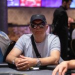 Ein Foto von vier Personen, die um einen Pokertisch sitzen und Poker spielen. Die Spieler haben Karten in der Hand und Pokerchips vor sich. Es herrscht eine spannende Atmosphäre, da alle konzentri