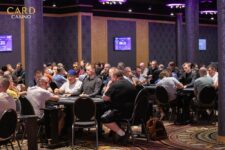 Alt-Text: Ein Mann und eine Frau spielen Poker an einem Tisch. Der Mann hat einen Stapel Chips vor sich liegen, während die Frau ihre Karten betrachtet. Beide haben konzentrierte Gesichtsausdr