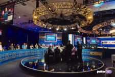 Ein Spieler sitzt an einem Pokertisch auf der Hauptbühne der World Series of Poker 2025. Im Hintergrund sind Zuschauer und weitere Tische zu sehen, während der Spieler seine Karten betrachtet.