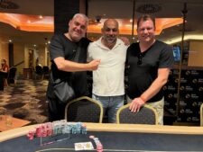 Ein großes Pokerturnier mit vielen Spielern an einem Tisch, die Karten halten und Pokerchips stapeln.